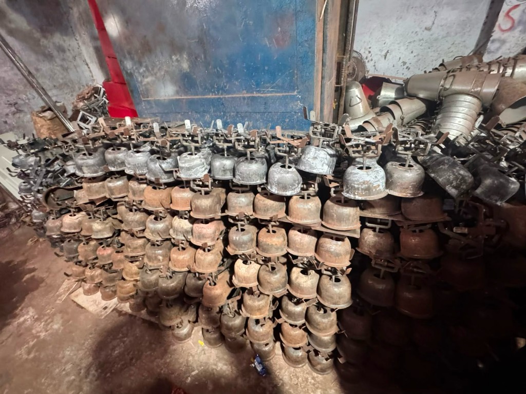 Stack of raw rusted fan cooler dome housings before coating